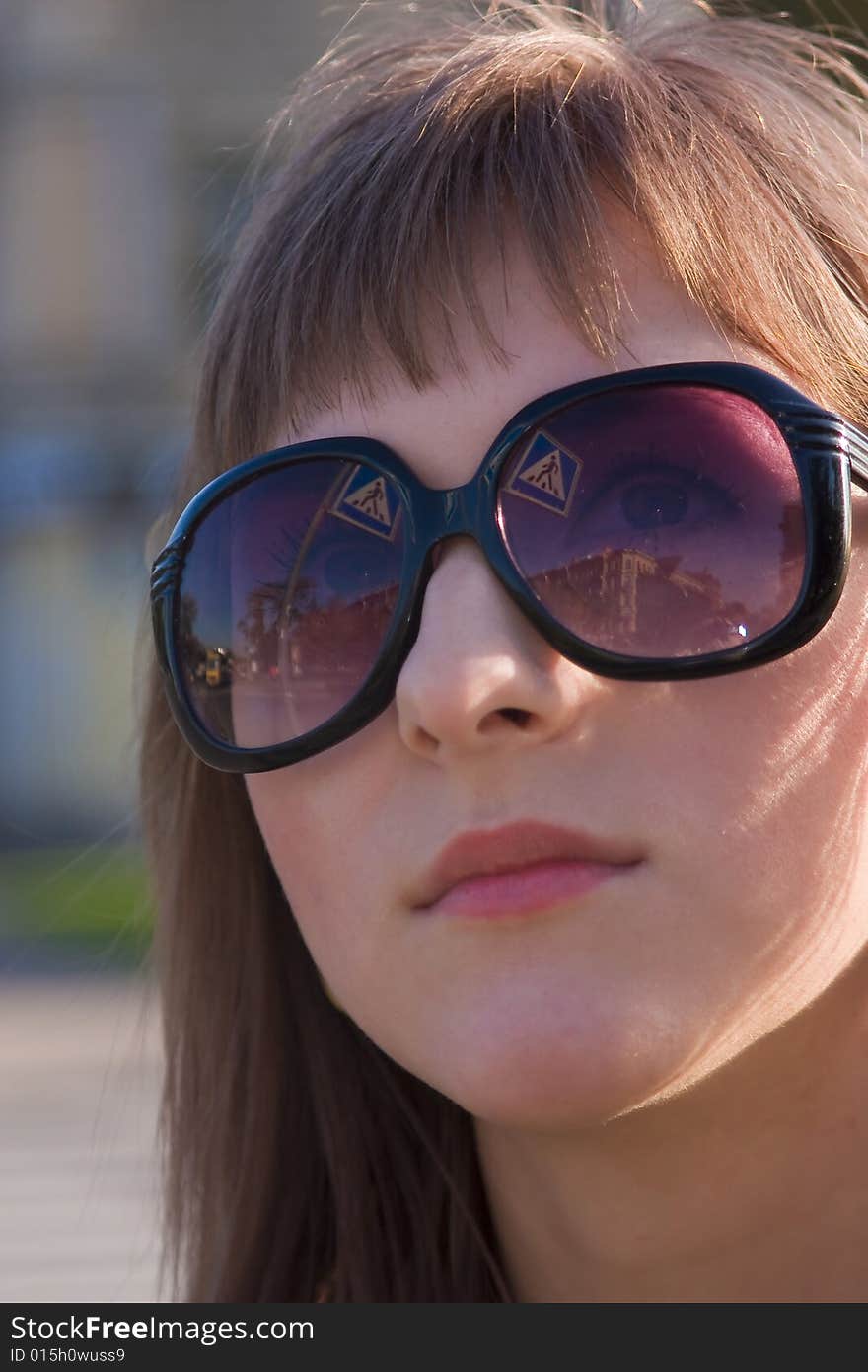 Portrait of a young woman in black glasses looking on a traffic sign. Portrait of a young woman in black glasses looking on a traffic sign