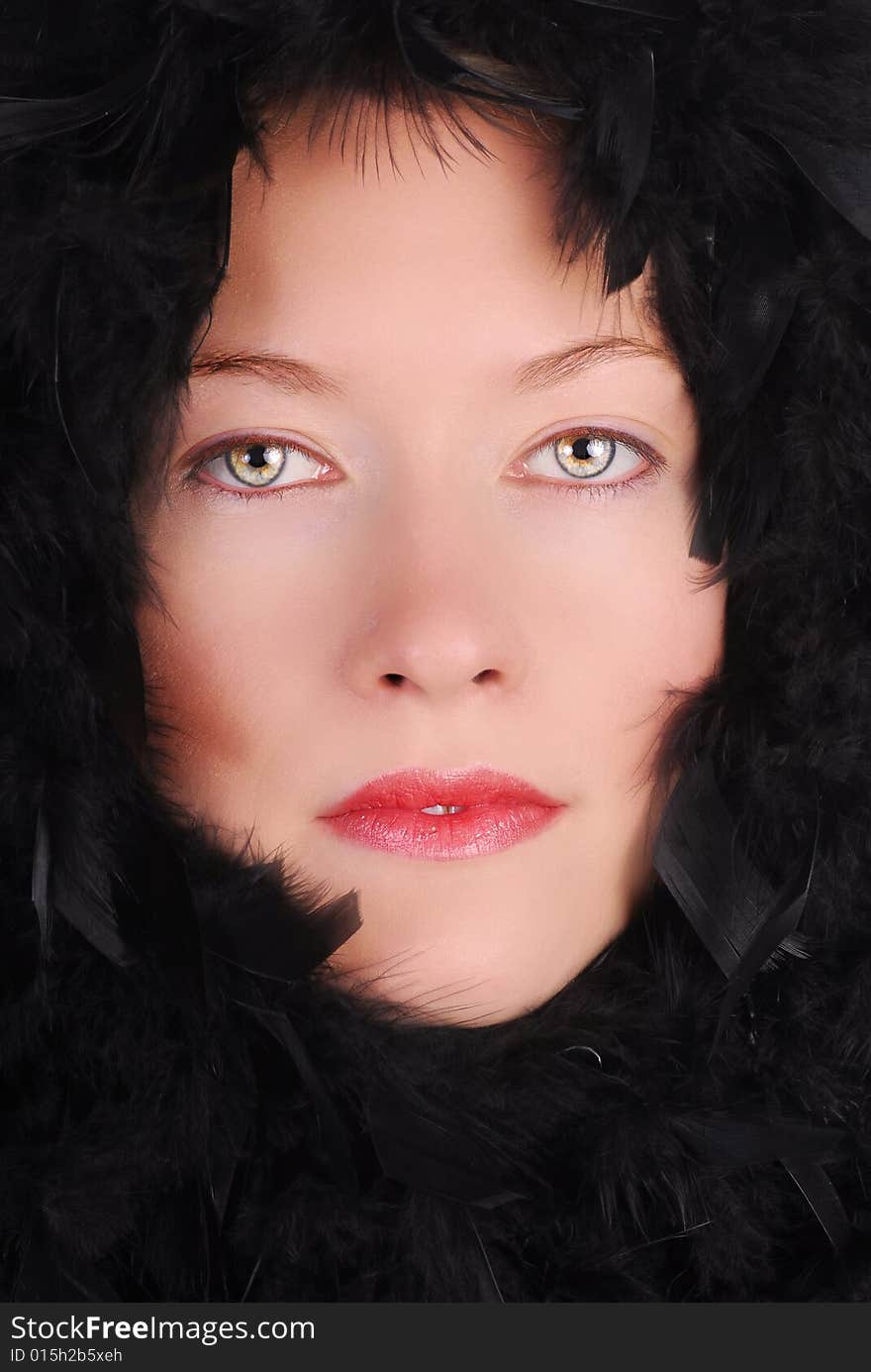 High fashion portrait of an attractive woman with black feathers surrounding her face. High fashion portrait of an attractive woman with black feathers surrounding her face