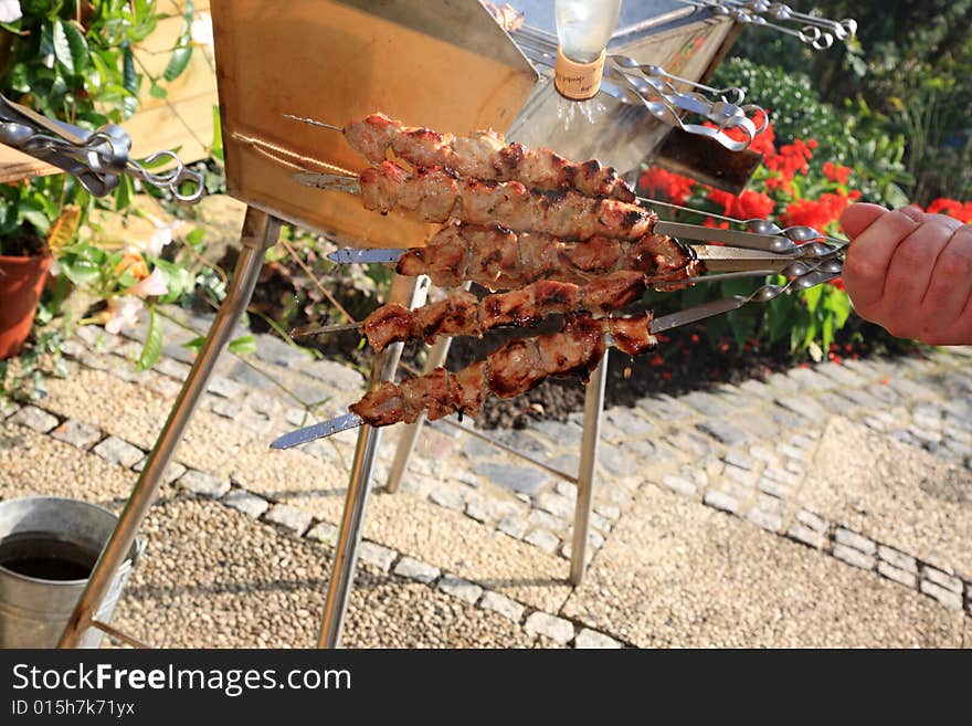 Hand with roasted shish kebab.