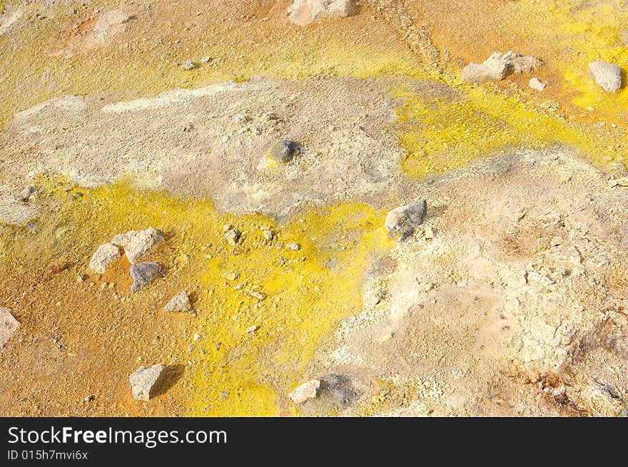 Colorful suplhur landscape. Small rocks lying around. Orange yellow soil.