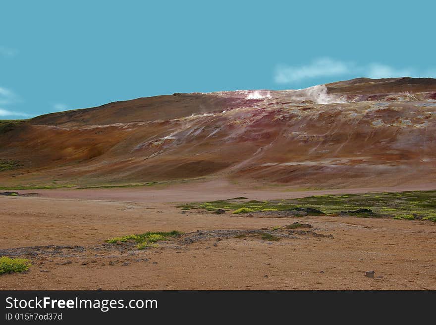 Sulphur fissures on a barren rocky hills. Clear blue skies.