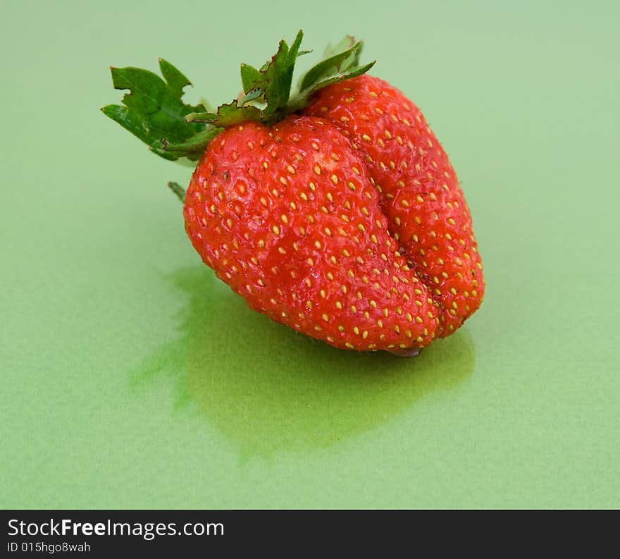 Red strawberry isolated on green