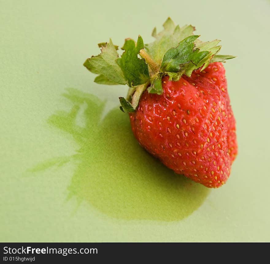 Red strawberry isolated on green