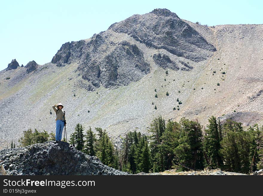 A young woman looking back across the mountain tops she has climbed.  California U.S.A. A young woman looking back across the mountain tops she has climbed.  California U.S.A.