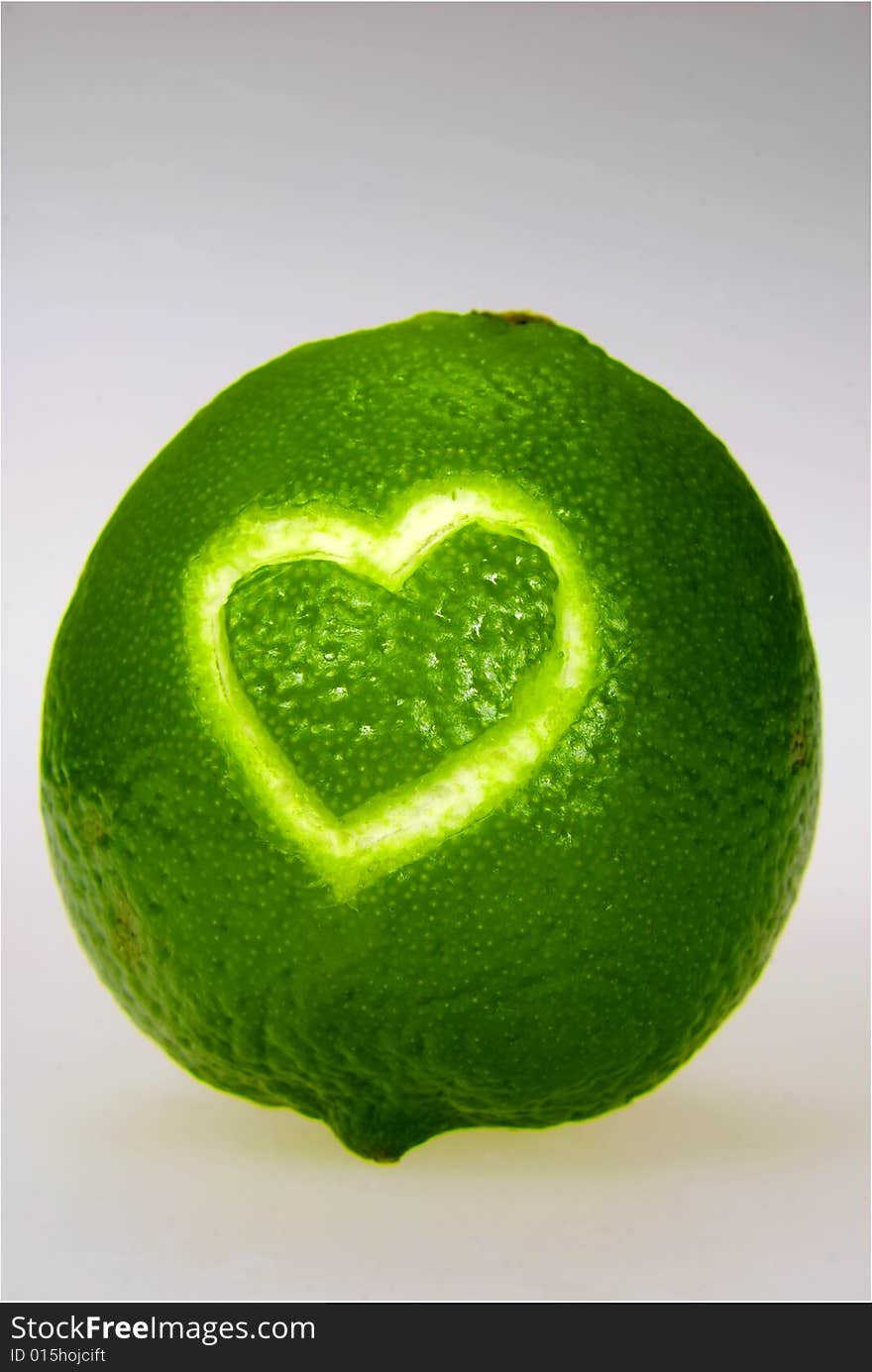 A lime with a heart carved into its skin. A lime with a heart carved into its skin