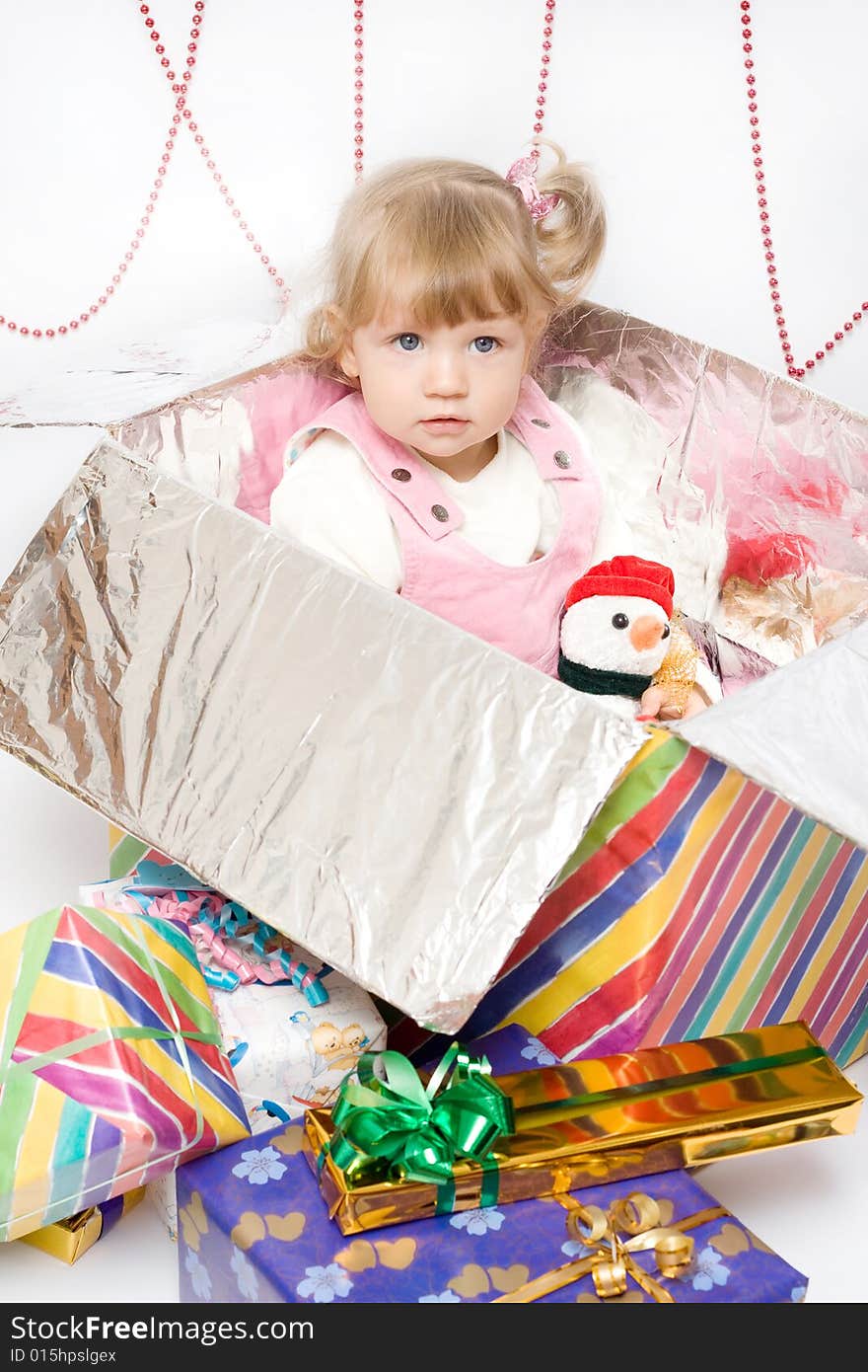 Happy infant with gifts in the decorated christmas box;