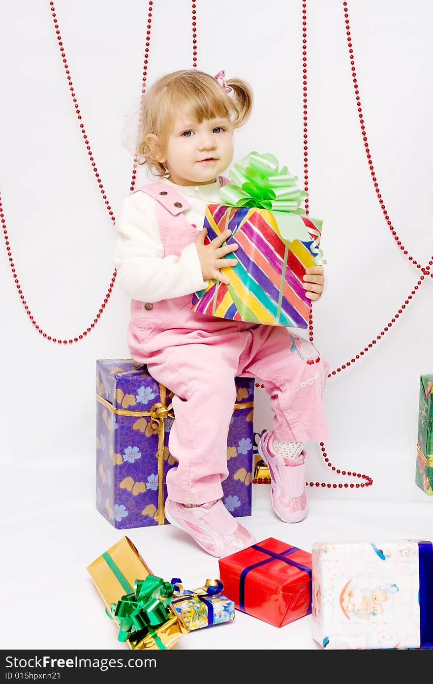 Happy infant with gifts in the decorated christmas box;