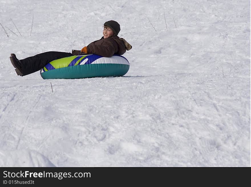 Boy sliding downhill on tube. Boy sliding downhill on tube