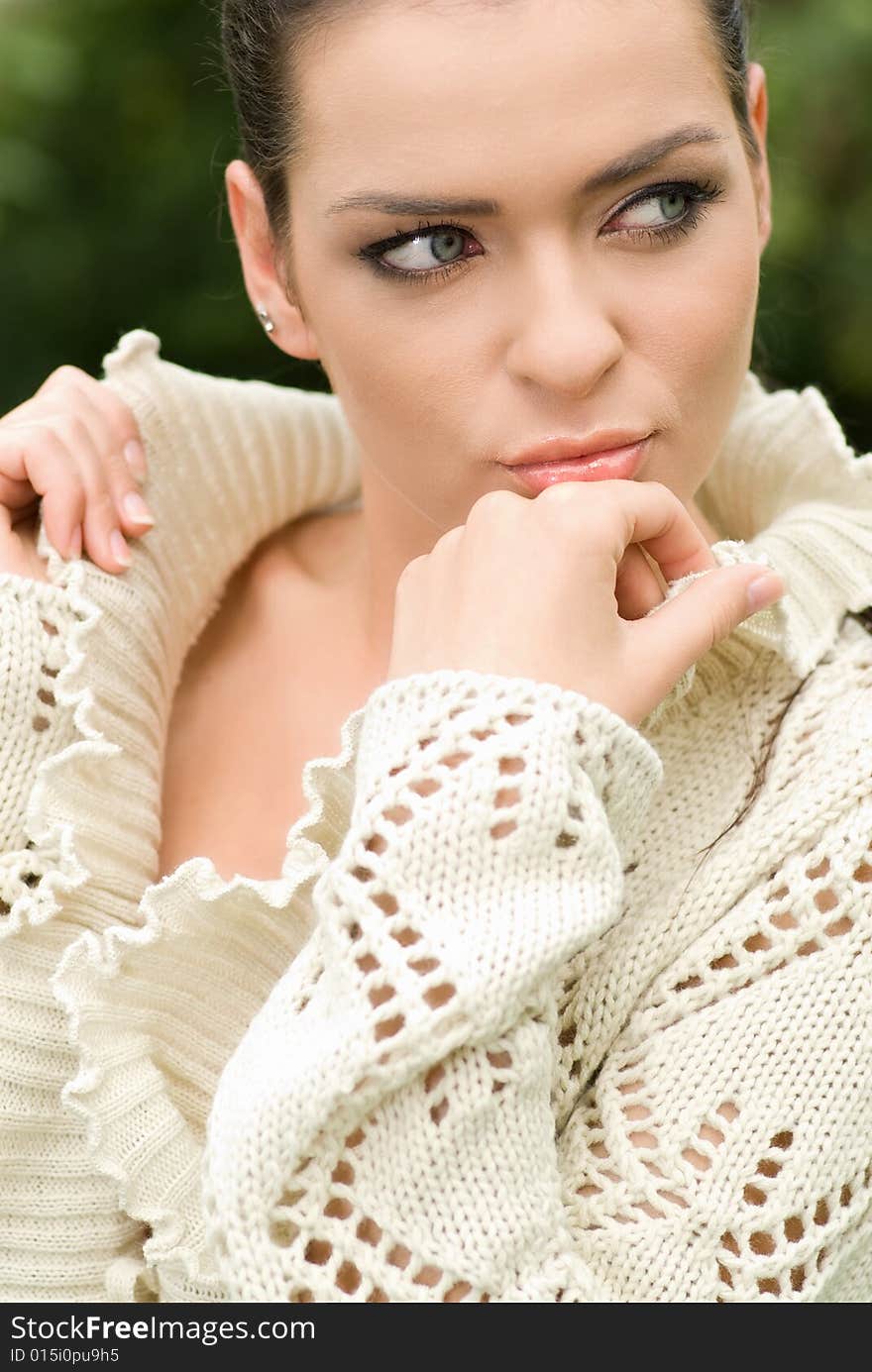 Portrait of beautiful woman in park. green background