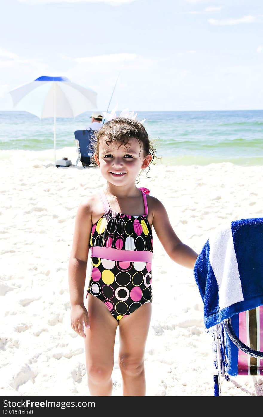 Beautiful little girl on the beach smiling with her swimsuit on enjoying her vacation. Beautiful little girl on the beach smiling with her swimsuit on enjoying her vacation.