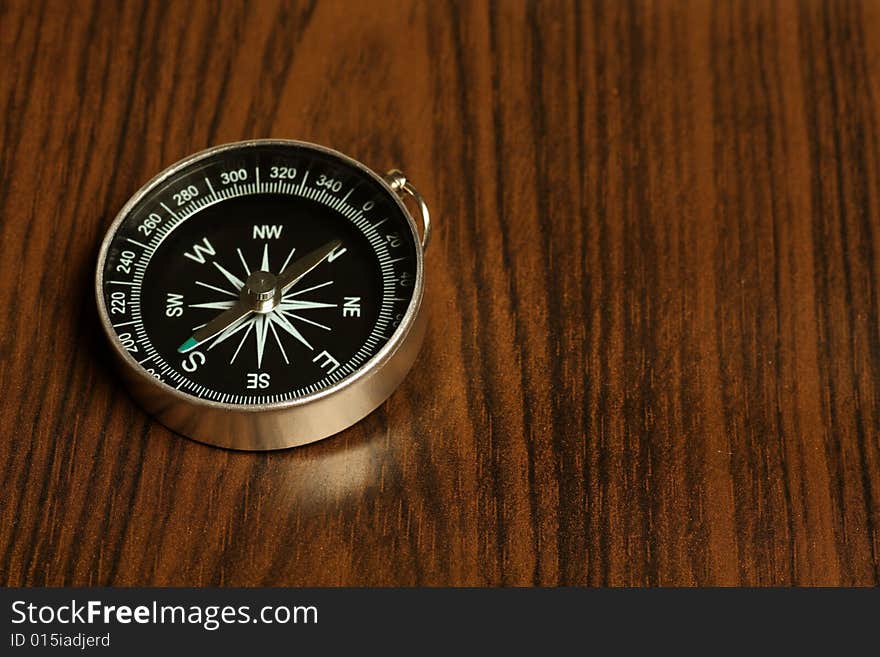 Magnetic compass on a wooden background