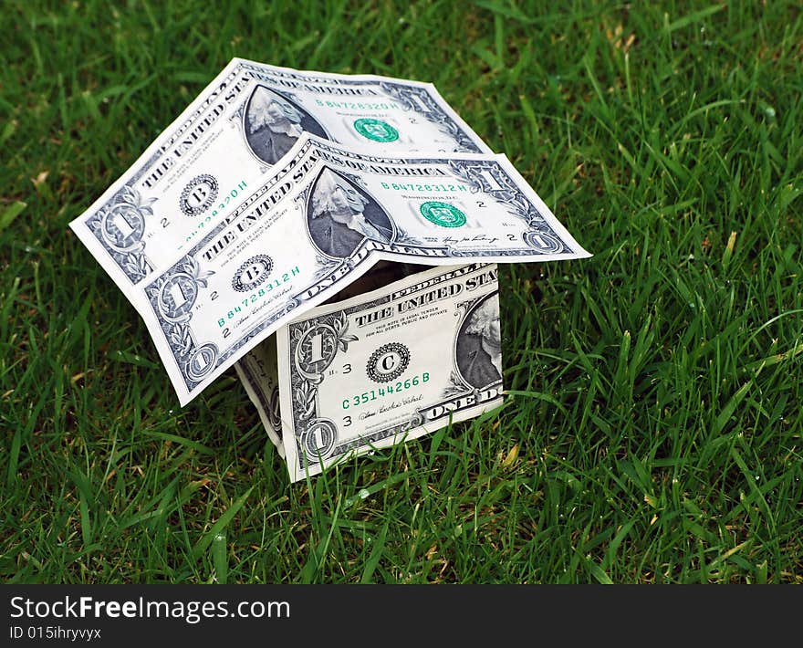 Conceptual image showing house shape made from US dollars on grass. Conceptual image showing house shape made from US dollars on grass