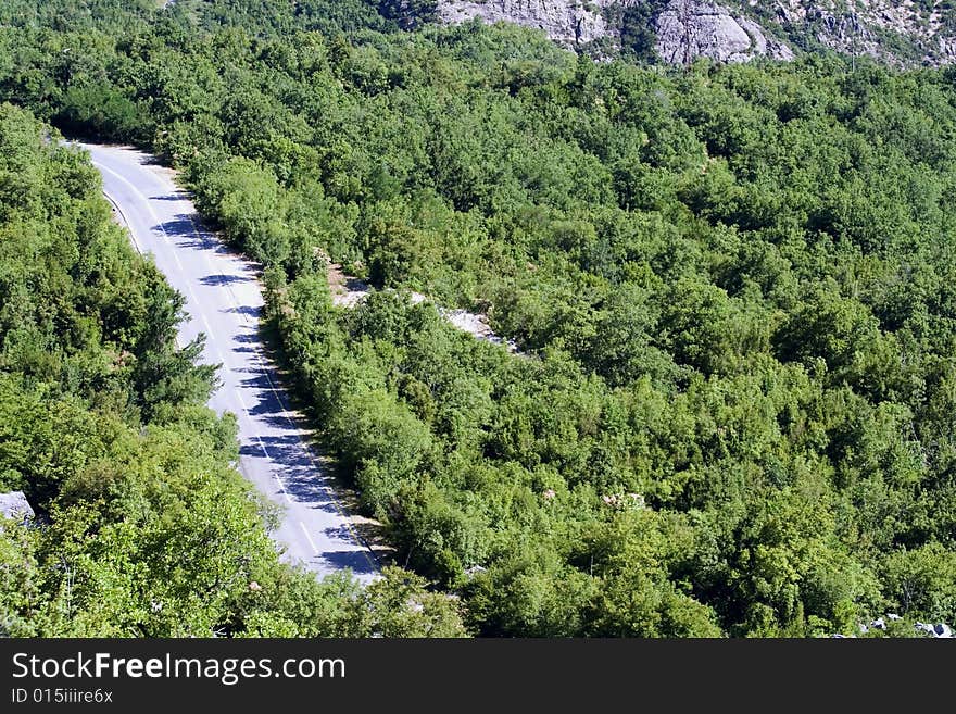 A road in the mountains with the growing trees on it in one of the european countries