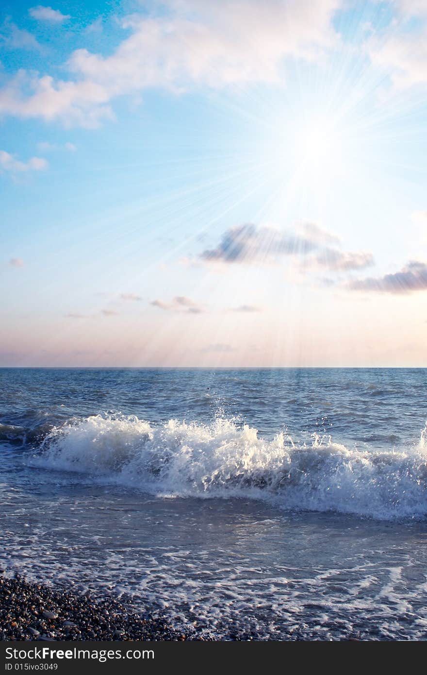 Bright sunbeams illuminate beautiful sea beachWave on sea beach under year blue sky and cloud