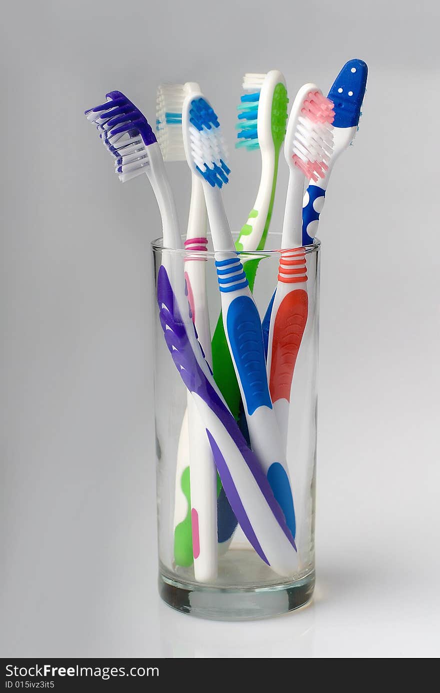 Five new toothbrushes in glass