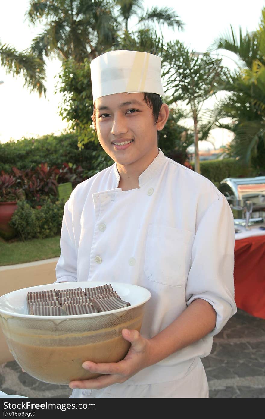 Chaf holding pastry food at buffet. Chaf holding pastry food at buffet