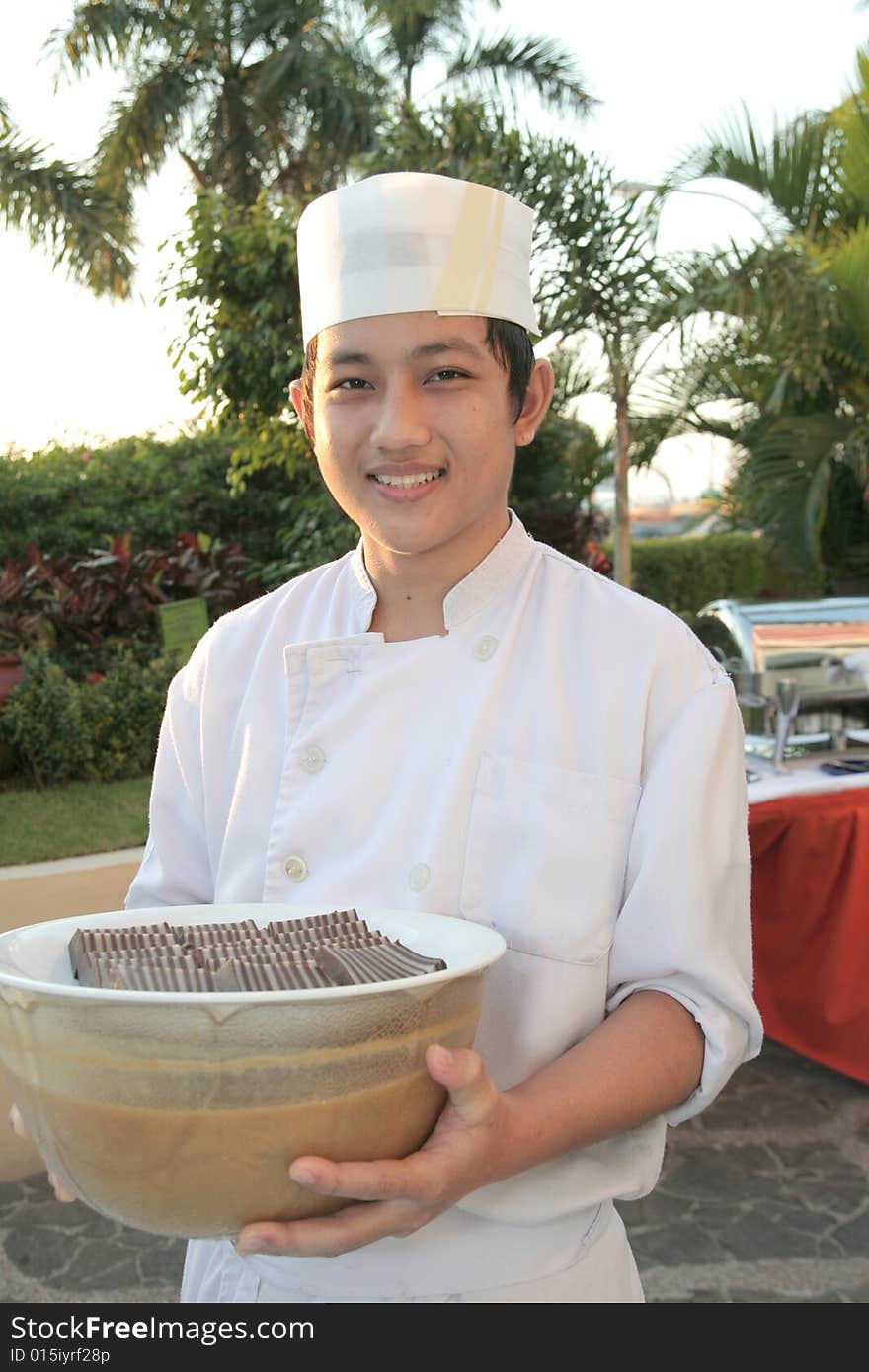 Chaf holding pastry food at buffet. Chaf holding pastry food at buffet