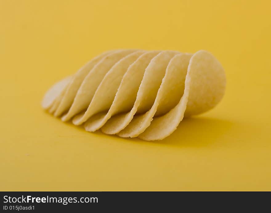 Chips close-up isolated on yellow background