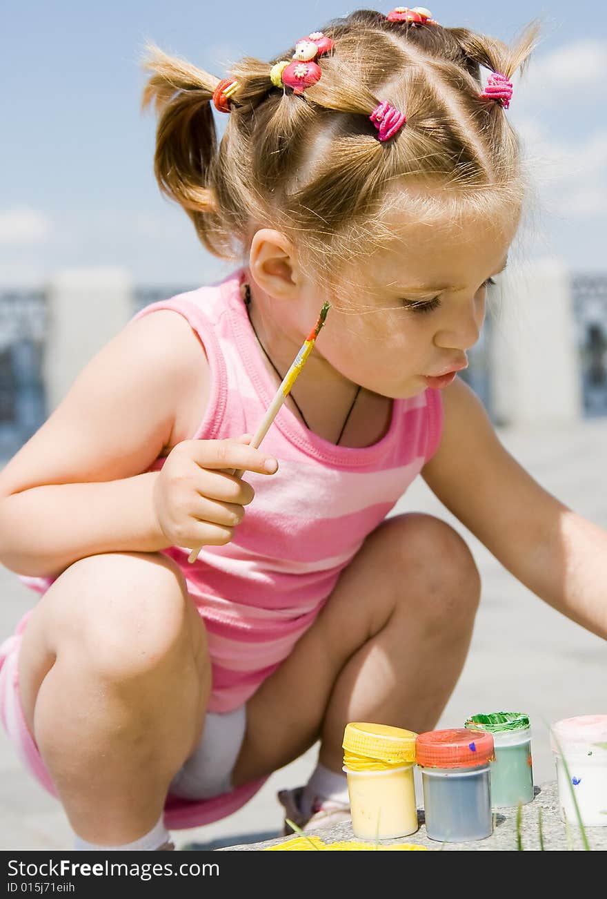 Little girl playing with paints