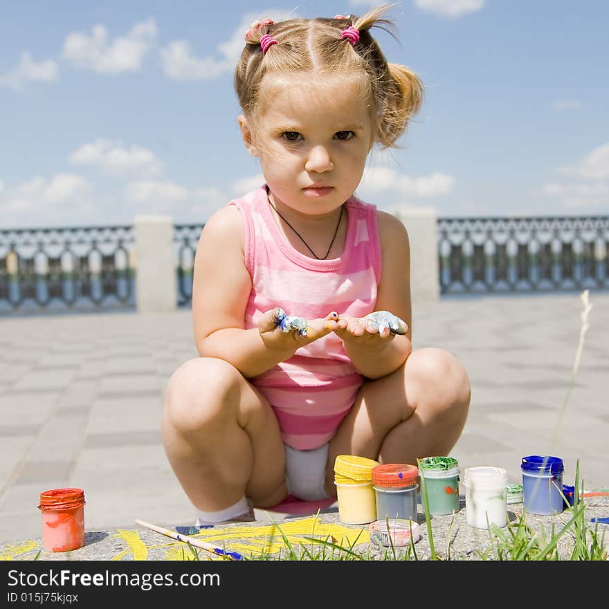 Little girl playing with paints