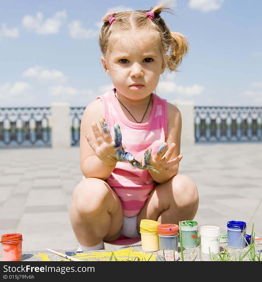 Little girl playing with paints