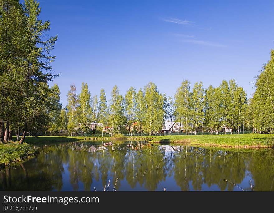 Lanscape with houses near lake under blue sky