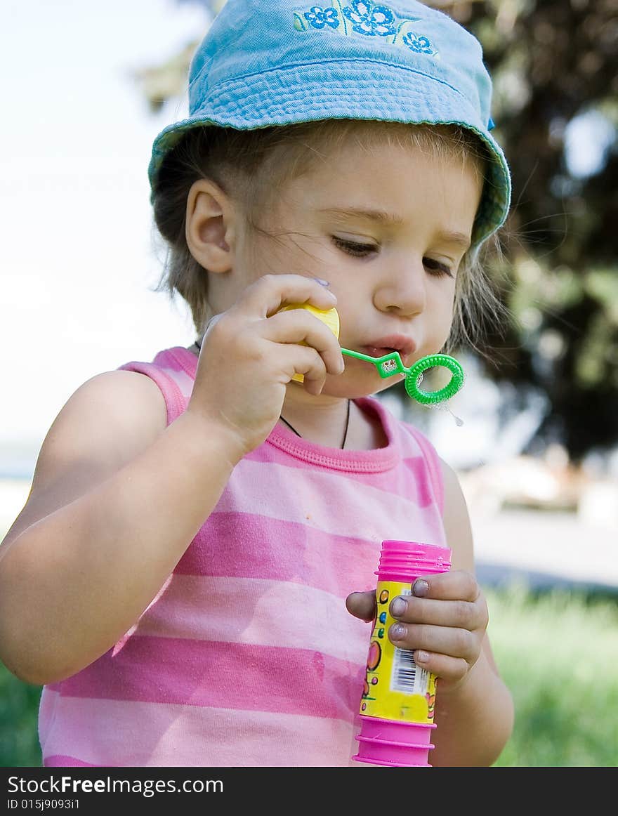 Little girl blowing bubbles outdoor