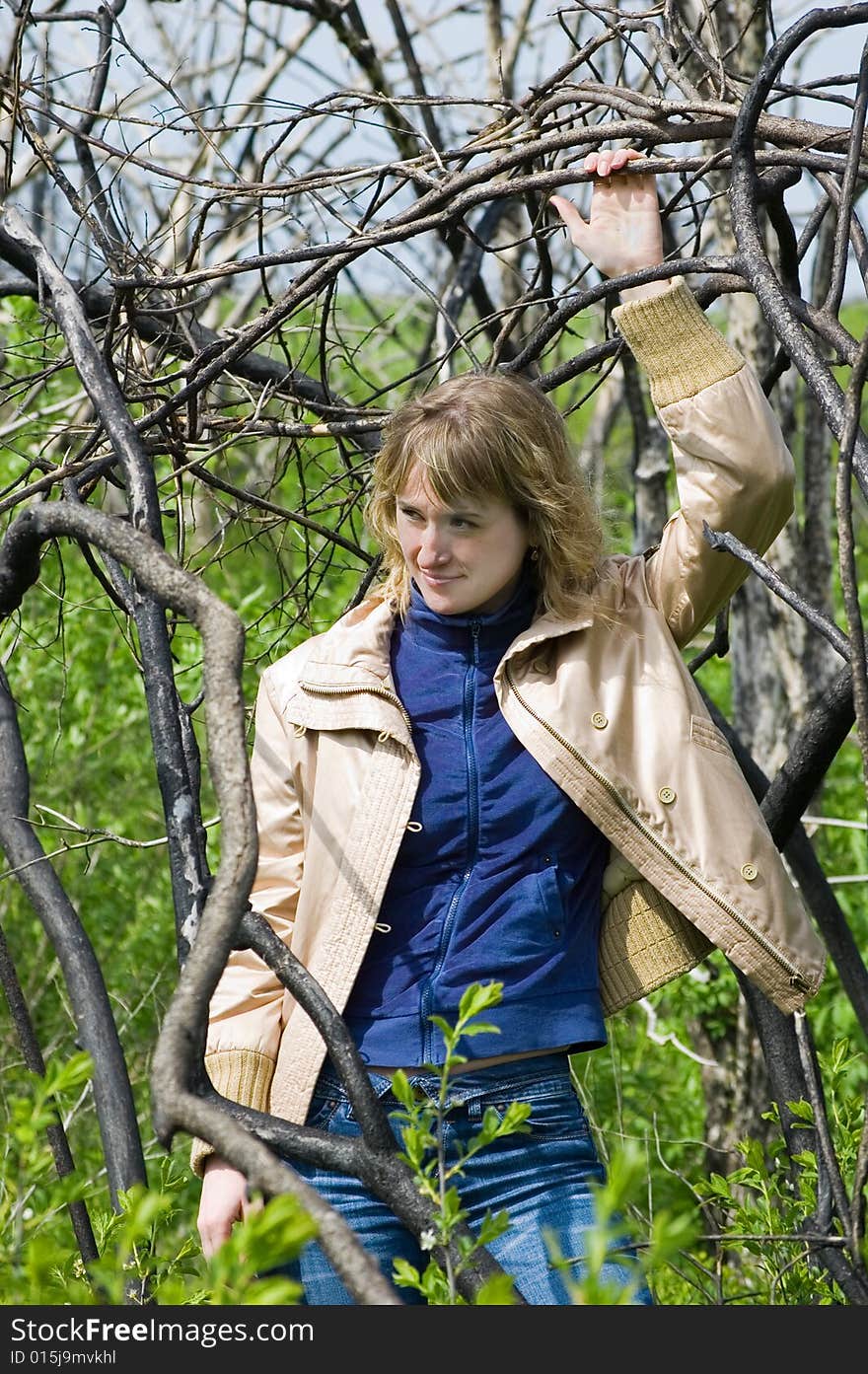 A view through the branches of a tree, focused on a pretty young teenage girl. A view through the branches of a tree, focused on a pretty young teenage girl