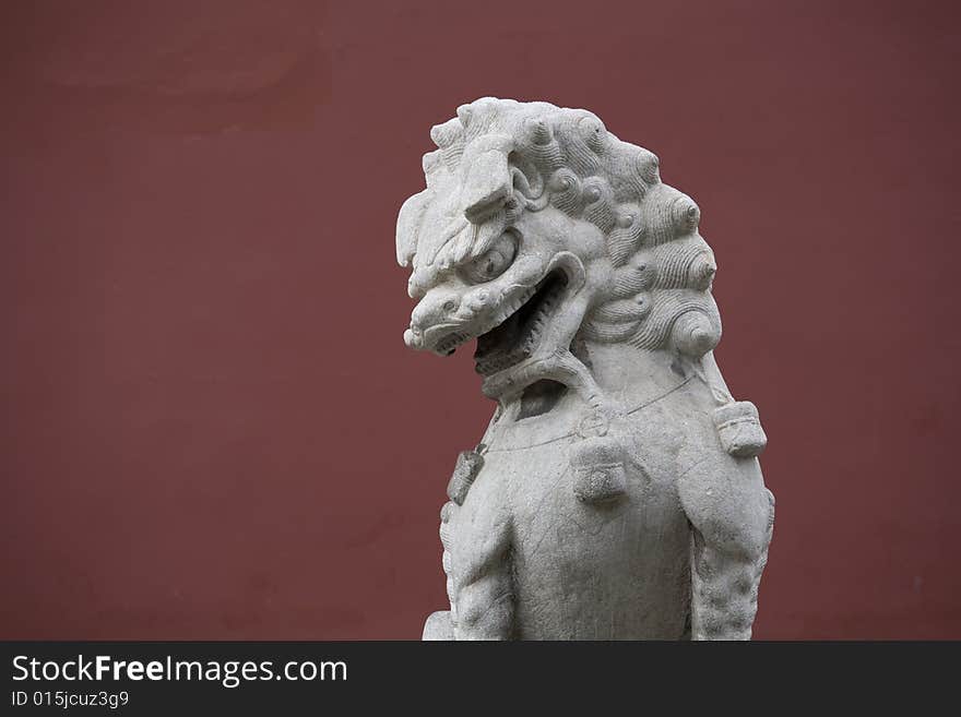 Stone sculpture lion at China，a deep red of background. Stone sculpture lion at China，a deep red of background