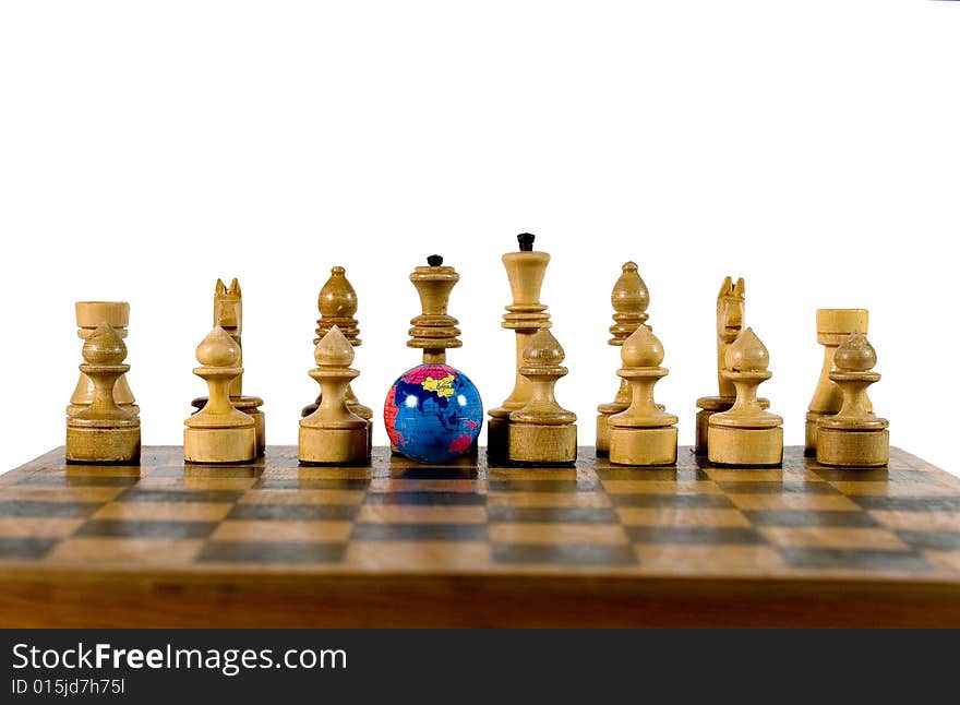 Small globe and wooden chess figures on an old chessboard