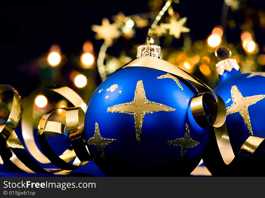 Christmas blue baubles with blurred lights in background, selective focus. Christmas blue baubles with blurred lights in background, selective focus