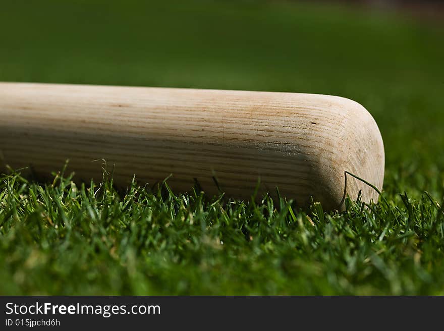 Baseball bat on the green grass of a ball field