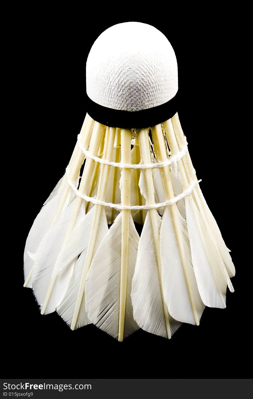 A white shuttlecock with feathers on the black background