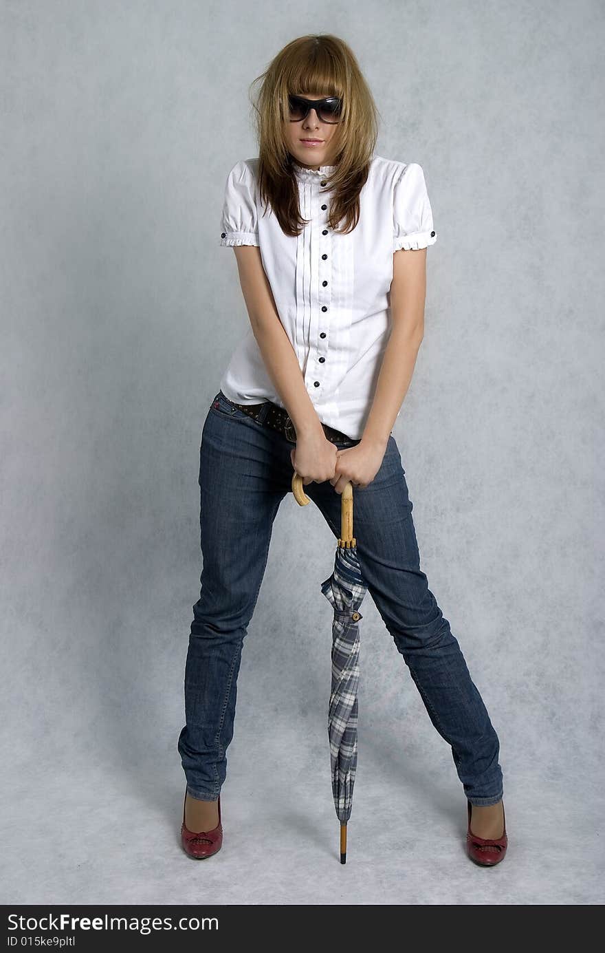 Stylish girl in white blouse and blue jeans with umbrella