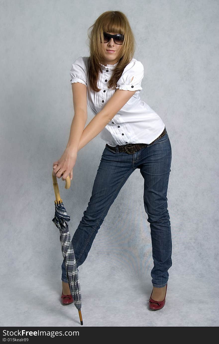 Stylish girl in white blouse and blue jeans with umbrella