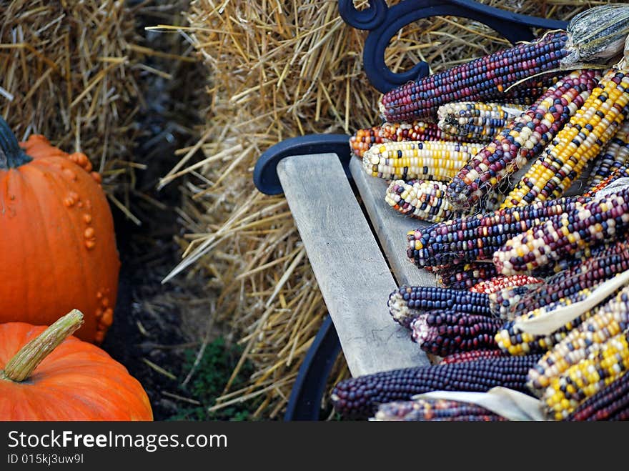 Indian corn and pumpkins by hay bales. Indian corn and pumpkins by hay bales.