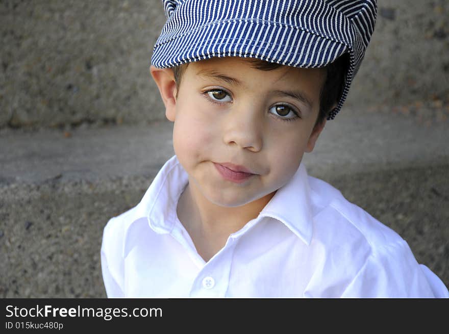 A yound child in a hat looking into the camera. A yound child in a hat looking into the camera