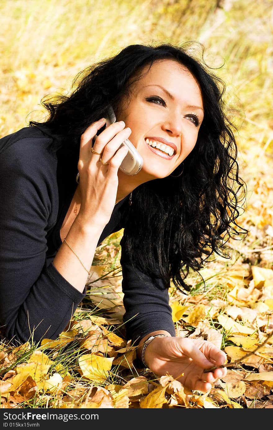 Pretty laughing girl talking on the cellphone in the park