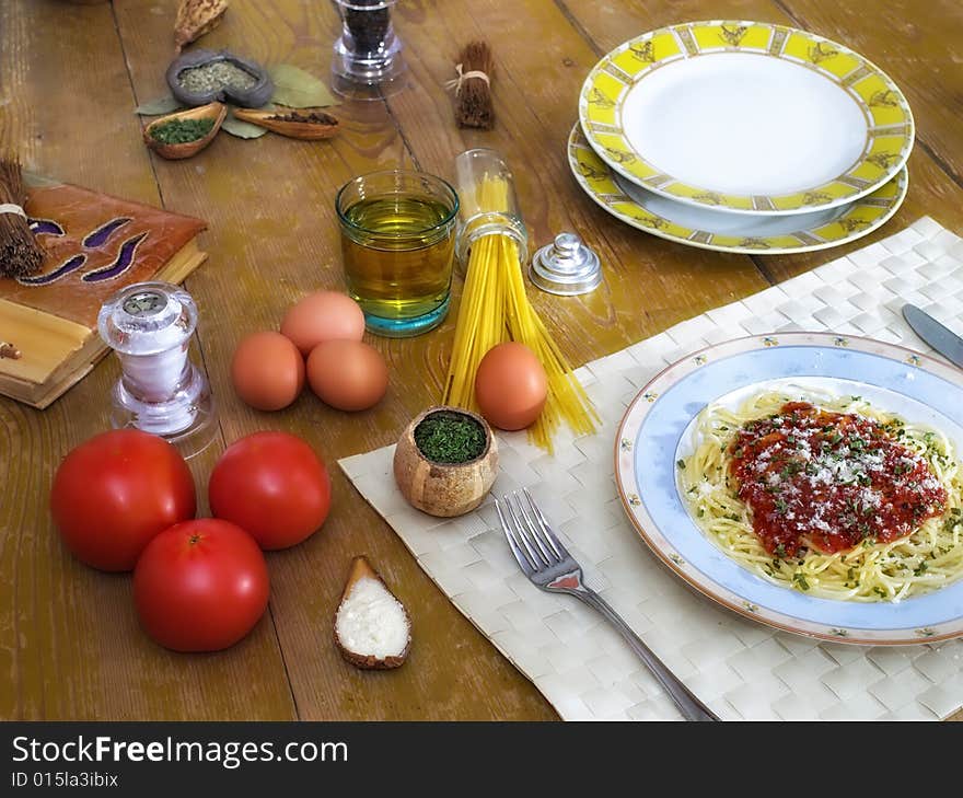 Spaghetti and tomato sauce on wooden desk