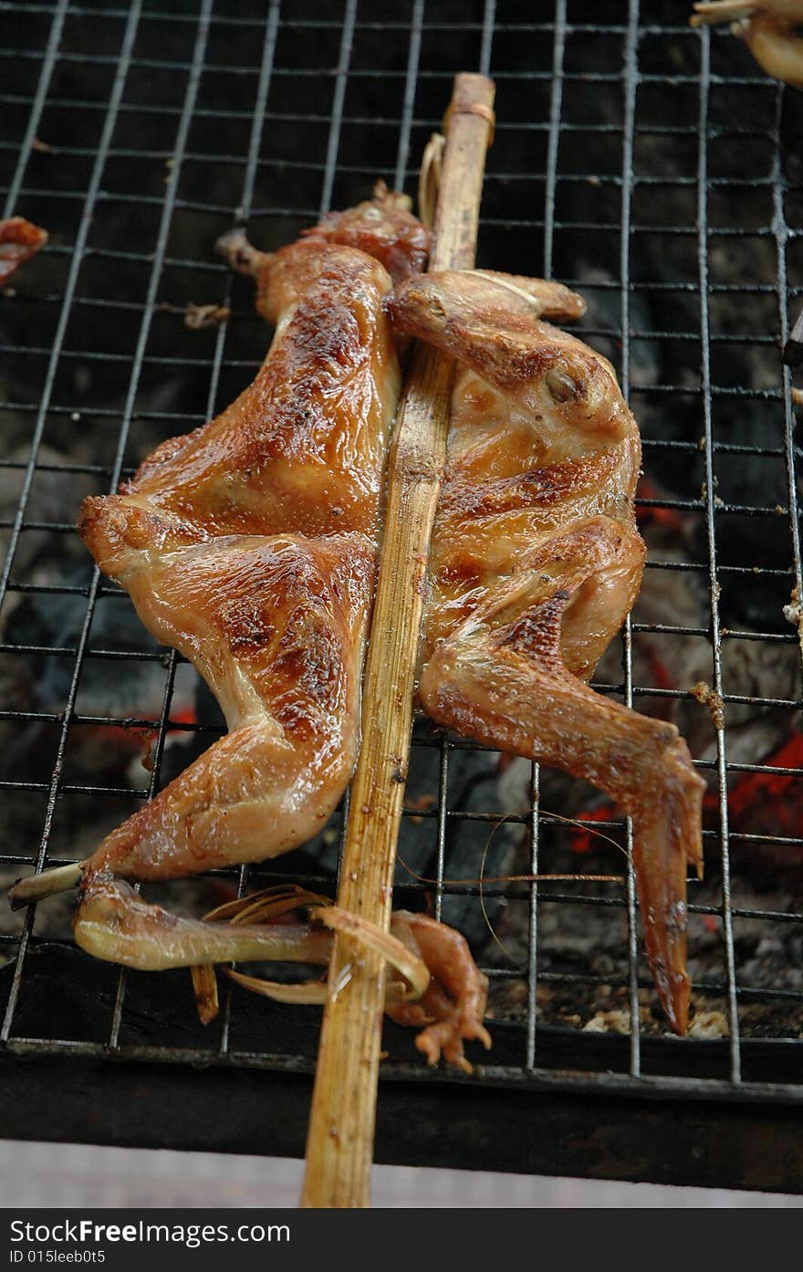 Chicken is grilled on a grill at a restaurant. Chicken is grilled on a grill at a restaurant.