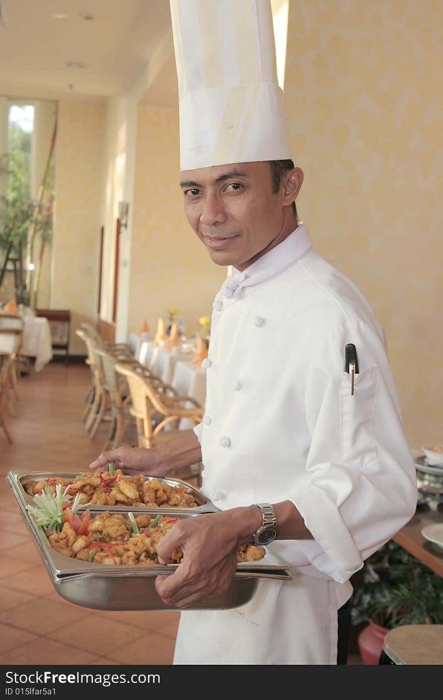 Chef carrying food on chafing dish for buffet. Chef carrying food on chafing dish for buffet