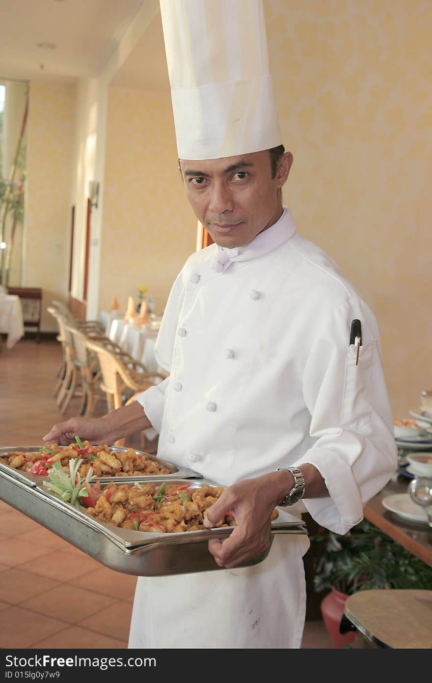 Chef carrying food on chafing dish for buffet. Chef carrying food on chafing dish for buffet