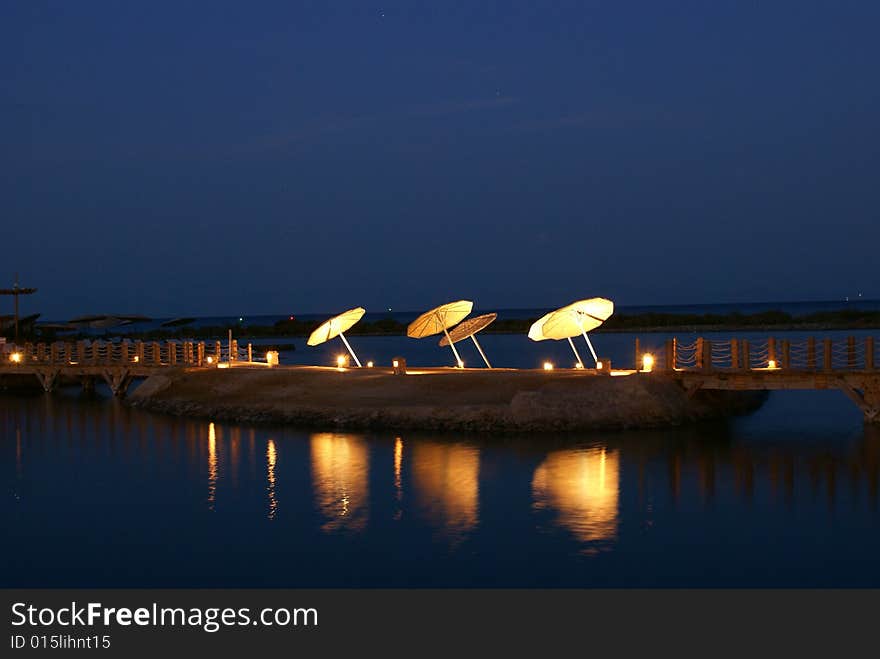 Night pier with umbrellas in Egypt.