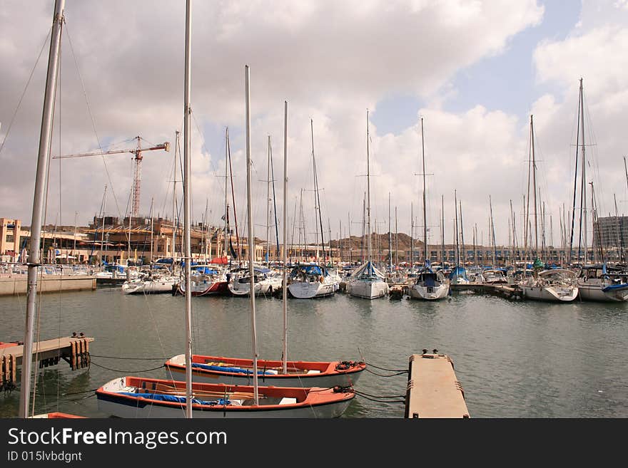 Port with sailboat and yachts in cloudy day