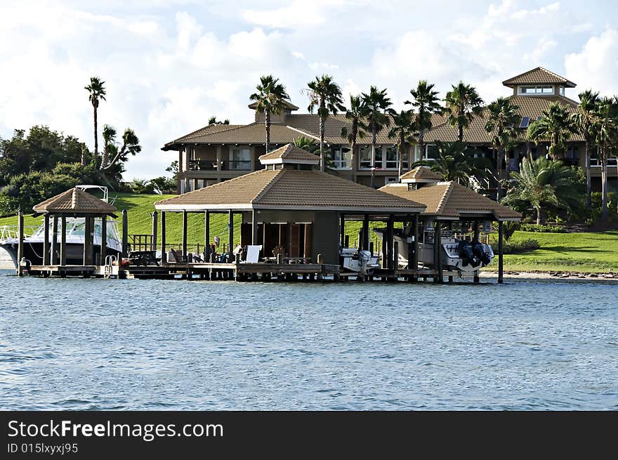 Beautiful tropical home surrounded by water, tropical plants, and two boat houses. Beautiful tropical home surrounded by water, tropical plants, and two boat houses.