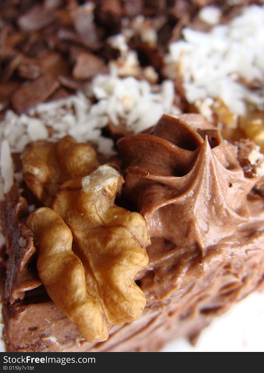 Chocolate cake covered with dried coconut, walnuts and coating glaze