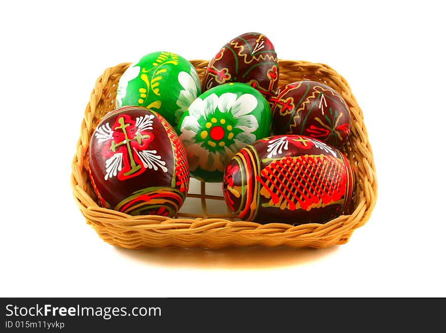 Six Easter eggs in a basket on a white background