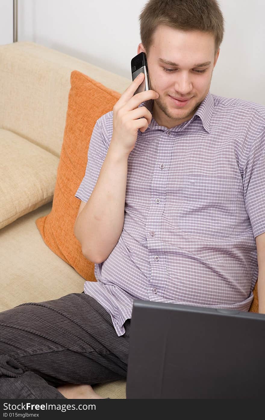 Casual guy sitting on sofa with laptop. Casual guy sitting on sofa with laptop