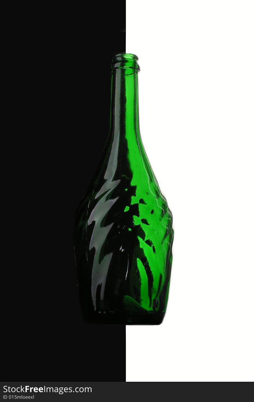 Green bottle on the border of white and black. Green bottle on the border of white and black.