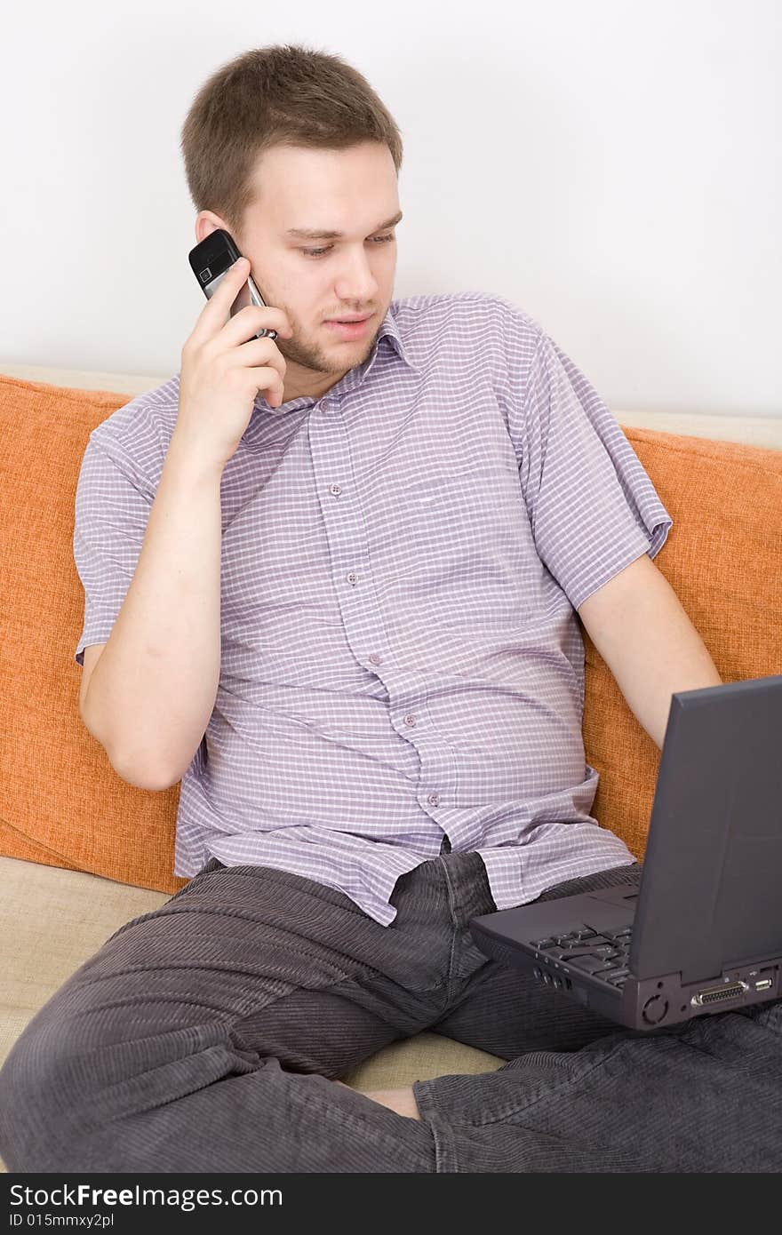 Casual guy sitting on sofa with laptop. Casual guy sitting on sofa with laptop